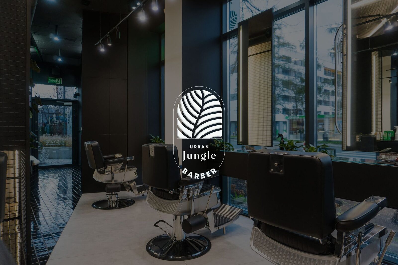 Wnętrze Urban Jungle Barber z fotelami barberskimi, zielenią i widokiem na miasto
